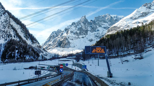 Road amidst snowcapped mountains against sky