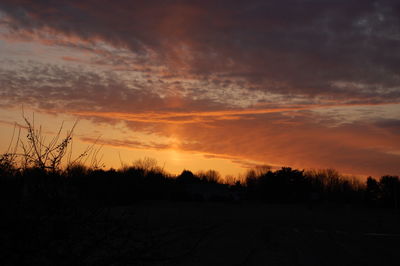 Scenic view of silhouette landscape against orange sky