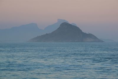Scenic view of sea and mountains against sky during sunset