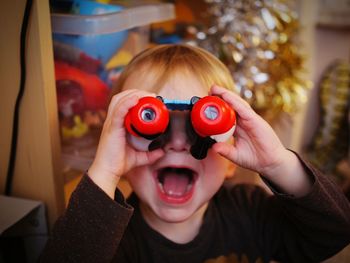 Close up of boy looking through binoculars at home