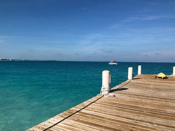 Pier over sea against blue sky