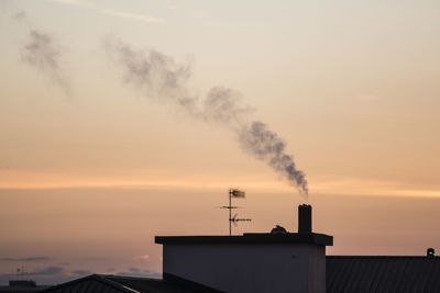 Smoke emitting from chimney against sky during sunset