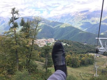 Low section of person on landscape against mountains