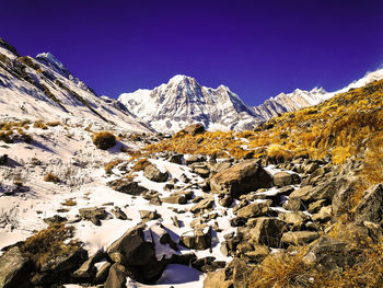 Scenic view of snowcapped mountains against clear sky during winter