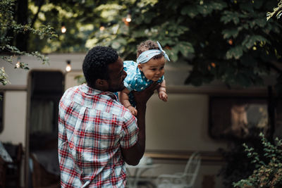 Father carrying daughter on shoulder outdoors