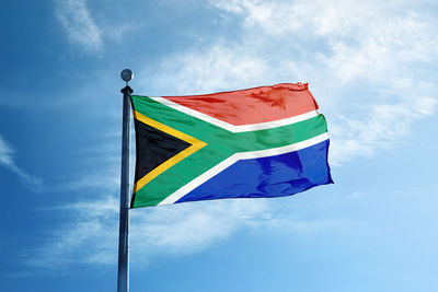 Low angle view of flag against blue sky