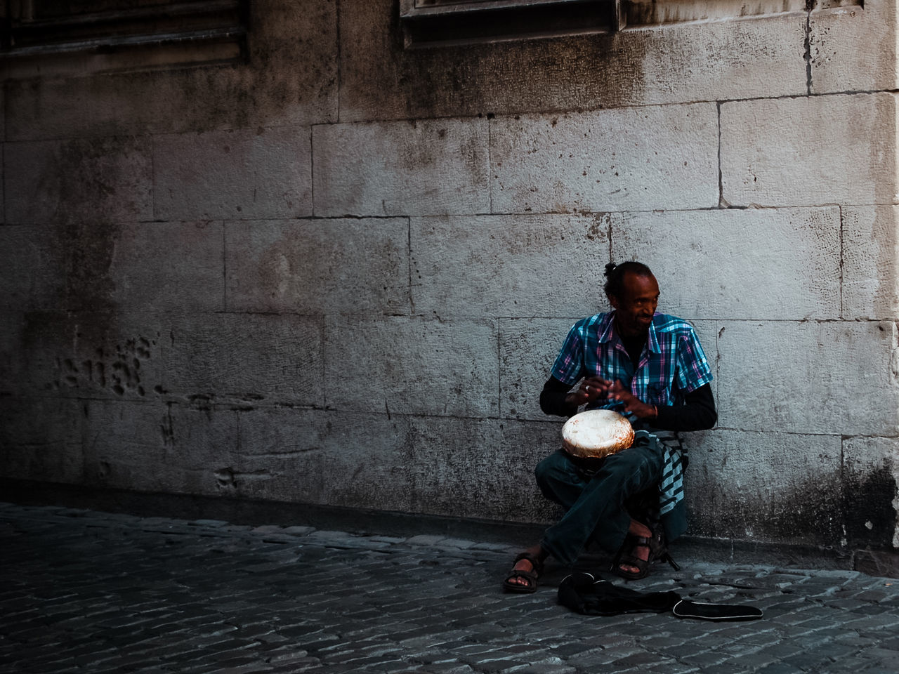 full length, sitting, architecture, one person, social issues, men, city, males, wall - building feature, adult, emotion, street, relaxation, casual clothing, front view, real people, footpath, dirty, depression - sadness