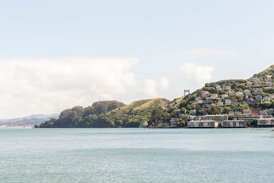 Scenic view of sea by buildings against sky