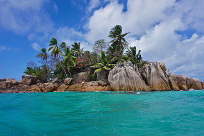 Scenic view of rocks by sea against sky