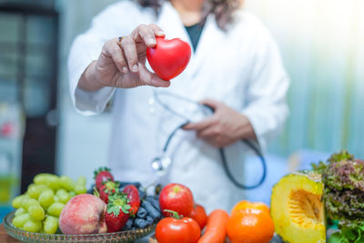 Midsection of woman holding apples