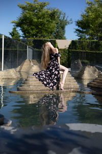 Rear view of woman in lake against trees