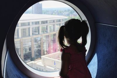 Girl looking through window