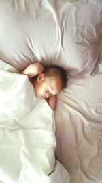 High angle view of baby boy lying on bed