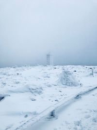 Snow covered land against sky