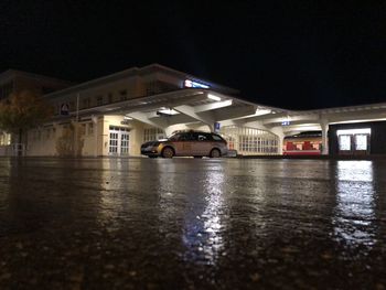 Illuminated wet street during rainy season at night