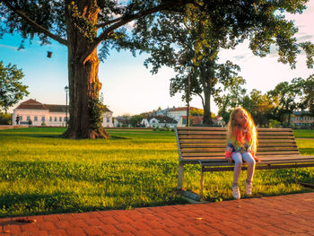 Little girl on field against sky