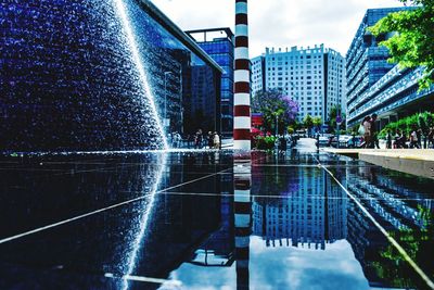 Fountain in city against sky