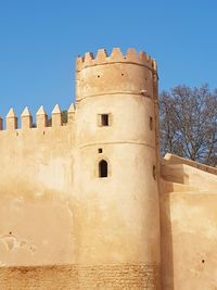 Low angle view of old building against clear blue sky