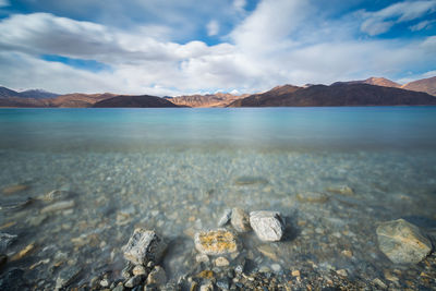 Scenic view of sea and mountains against sky