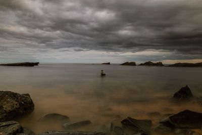 Scenic view of sea against storm clouds