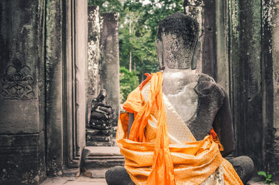 Stone statue of a seated buddha in a temple in cambodia. 