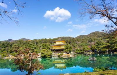 Scenic view of lake by trees against sky