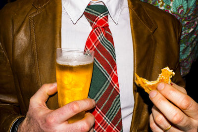 Midsection of man holding food and drink