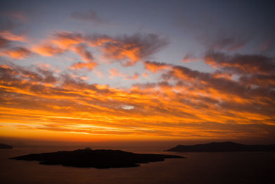 Scenic view of sea against dramatic sky during sunset