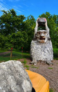 Stone sculpture on field against sky