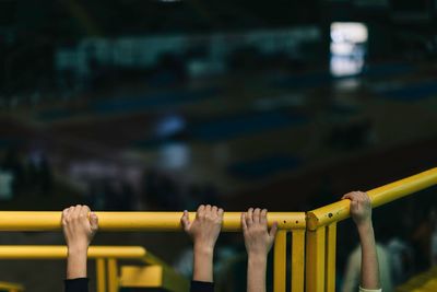 Cropped hands of children holding railing