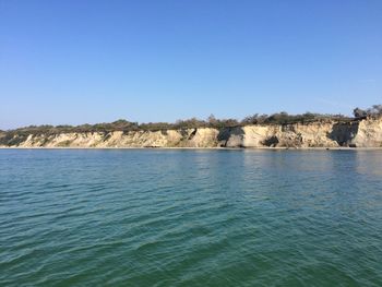 Scenic view of sea against clear blue sky