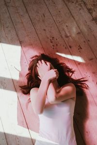 High angle view of woman lying on hardwood floor