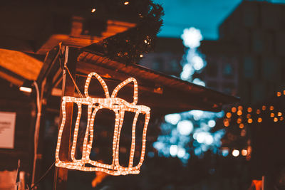 Low angle view of illuminated christmas lights hanging at night