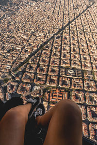 Spain, catalonia, barcelona, personal perspective of young woman riding helicopter over densely populated residential district