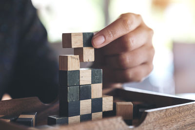 Cropped hand of man stacking toy blocks