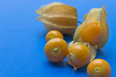 Close-up of fruits on table against blue background