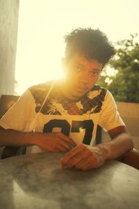 Portrait of young man sitting on table