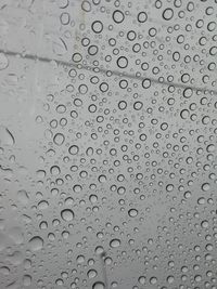 Full frame shot of raindrops on glass window