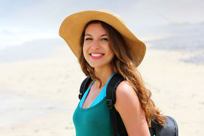 Portrait of smiling young woman standing at beach