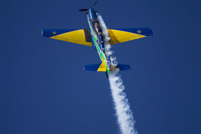 Low angle view of airplane against sky during airshow