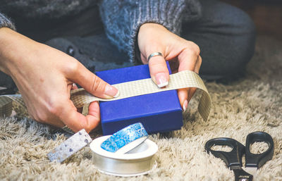 Close-up of woman wrapping gift box