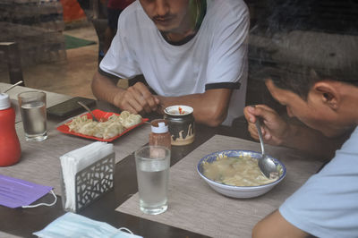 Midsection of woman having food at restaurant