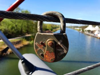 Close-up of padlocks on railing against river