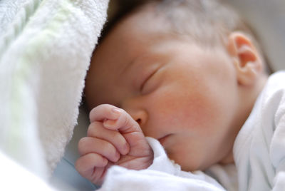 Close-up of baby girl sleeping on bed