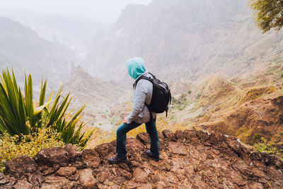 Man standing on land against mountains