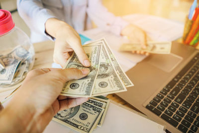 Businessman giving money to person on table