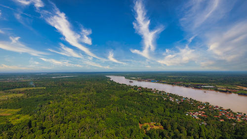 Aerial view of forest batanghari river , with muarojambi temple in the bright morning blue sky