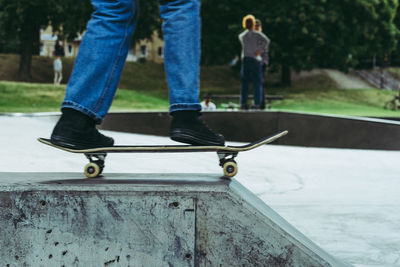 Low section of boy standing on skateboard