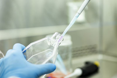 Midsection of scientist examining chemical in laboratory