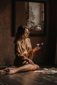 Young attractive female sitting with butterfly on her hand